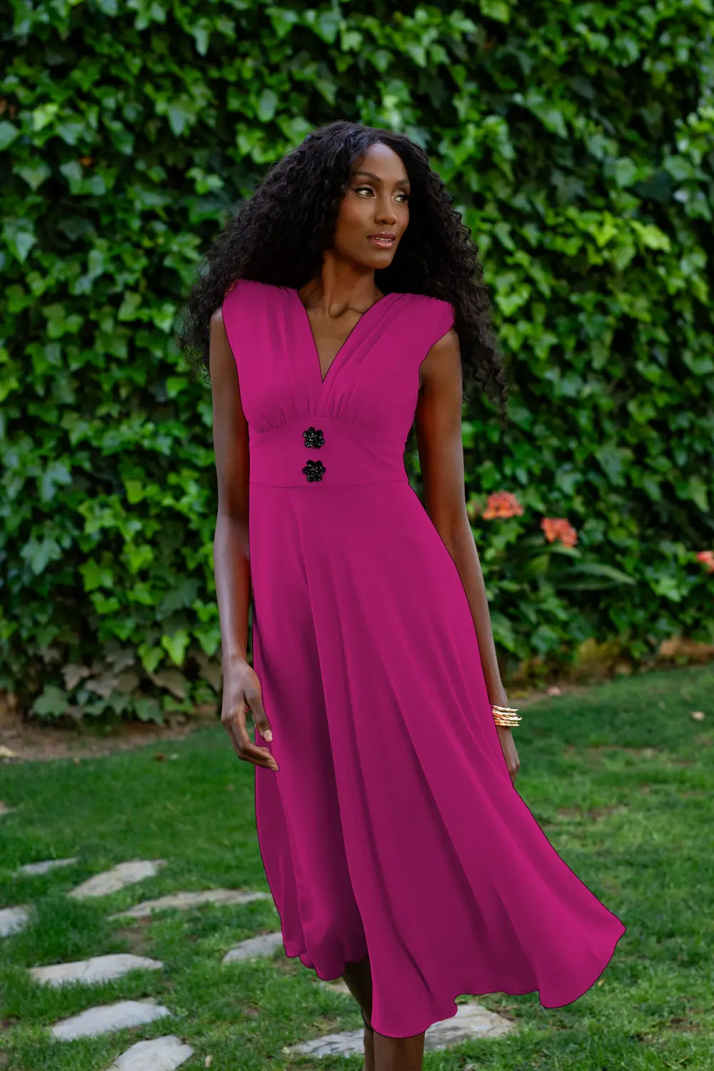 Vestido midi color buganvilla con corte evasé y flores en la cintura.