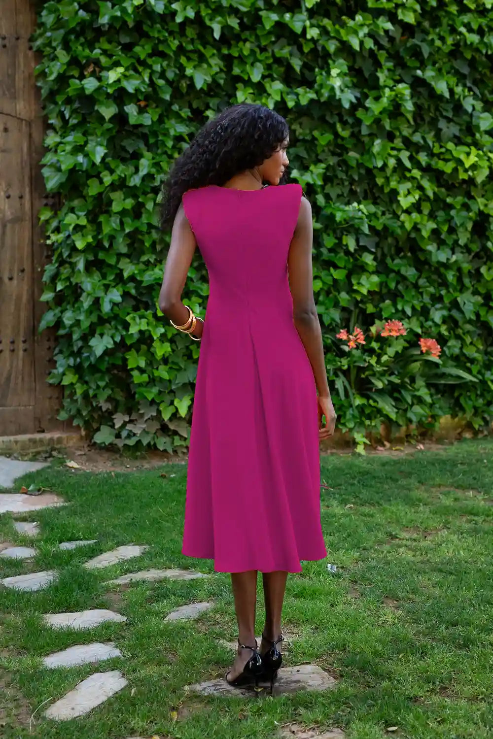 Vestido midi color buganvilla con corte evasé y flores en la cintura.