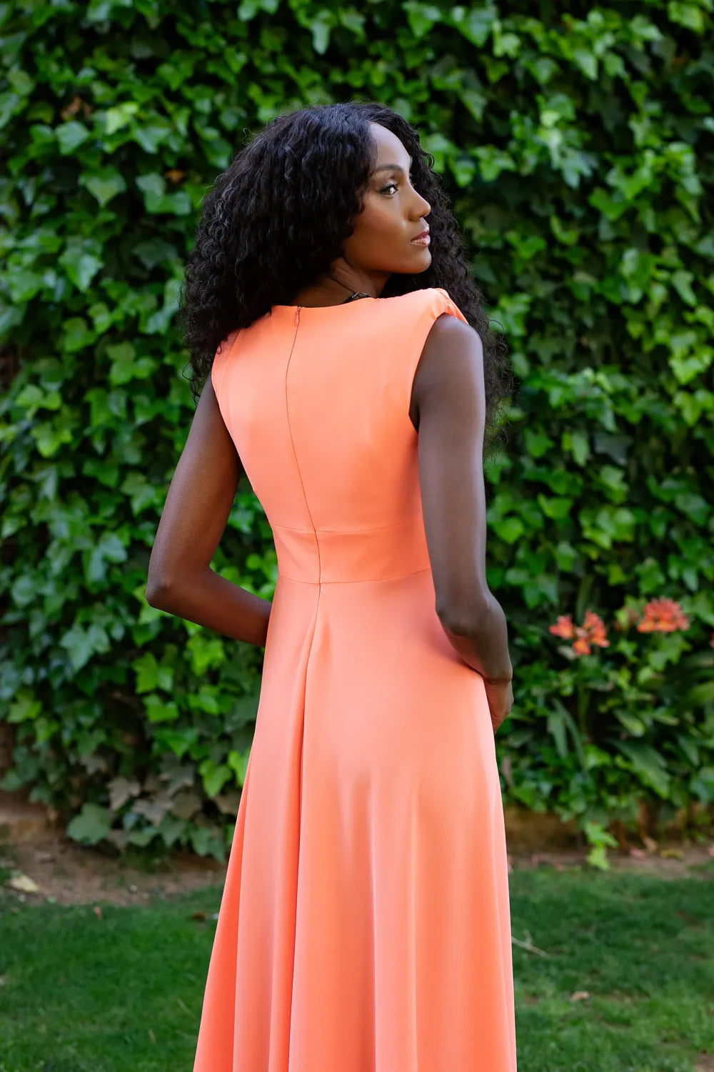 Vestido midi naranja con botones frontales. Escote en V y espalda cerrada.