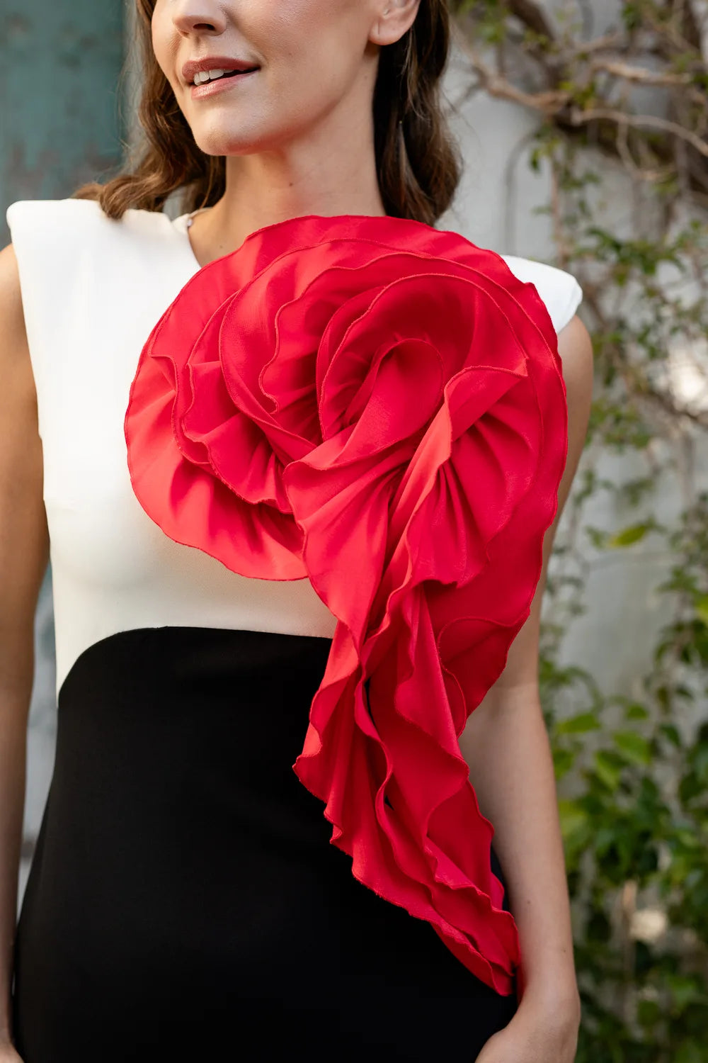 Vestido tricolor en blanco, negro y rojo con maxi flor en el pecho. Escote cerrado y espalda cerrada.