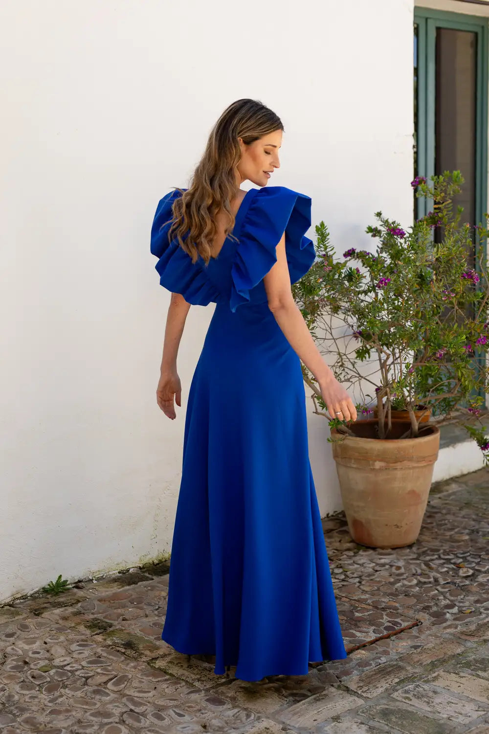 Vestido largo con maxi volantes en color tinta. Escote y espalda en V.