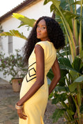 Vestido amarillo con decoración de rombos lateral. Escote en pico y espalda cerrada.