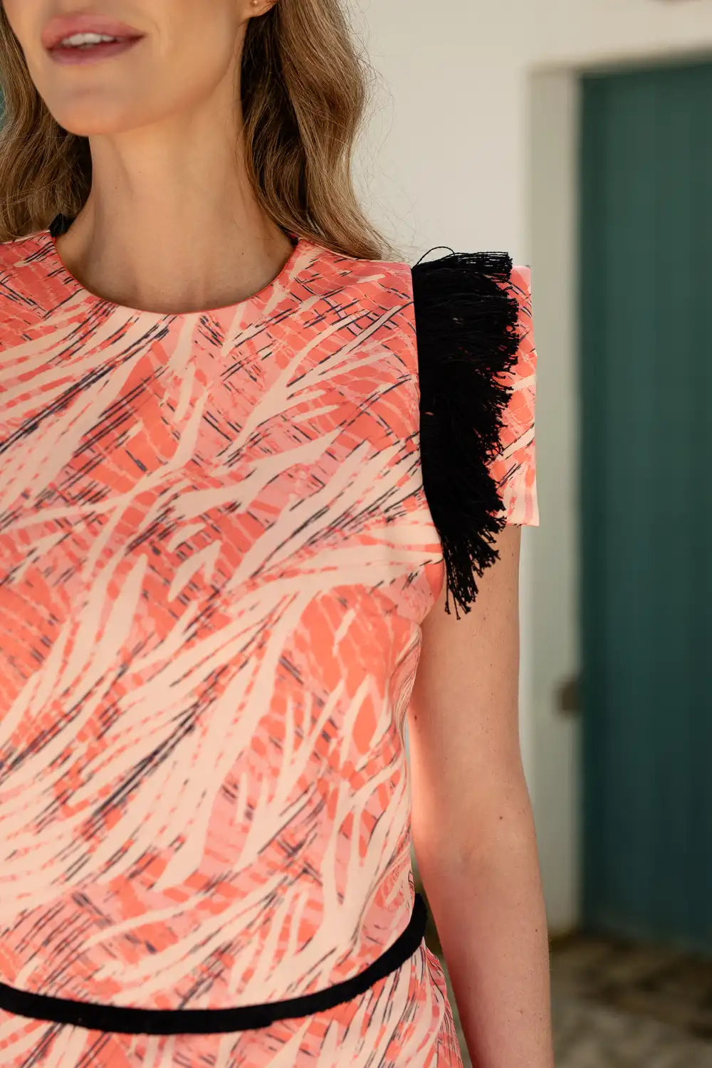 Vestido midi estampado coral con flecos en el hombro y en la cintura.