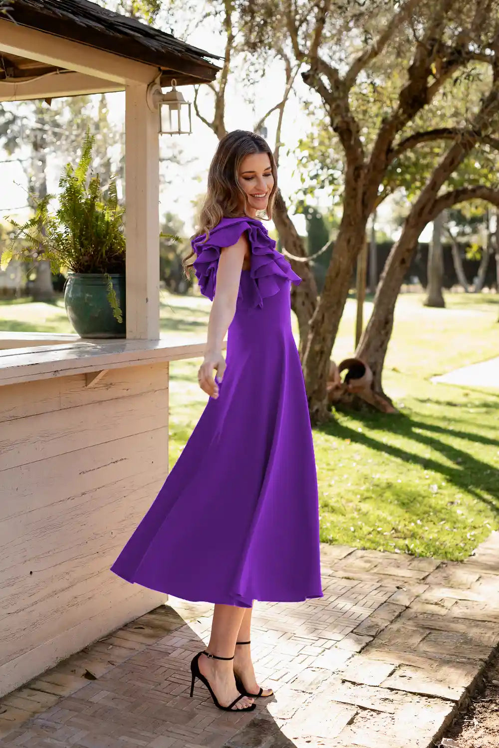Vestido midi morado con decoración de volantes en el hombro.