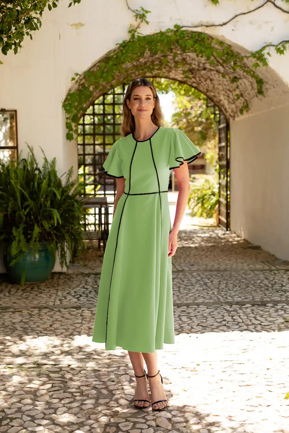 Vestido midi manzana con corte evasé y vivos en las mangas y volantes.