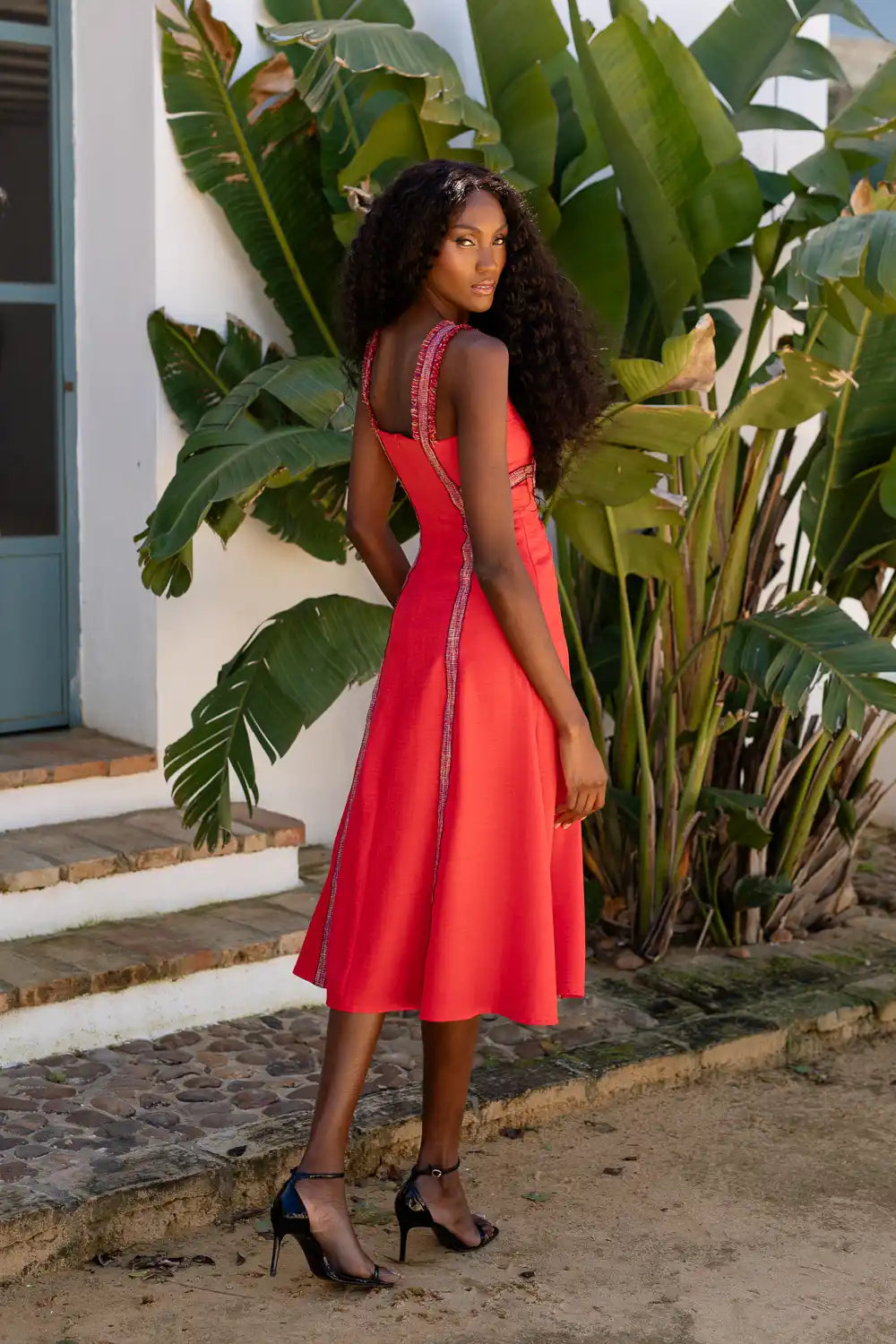 Vestido midi en color rojo rústico con tirantes y pasamanería. Escote en forma de caja.