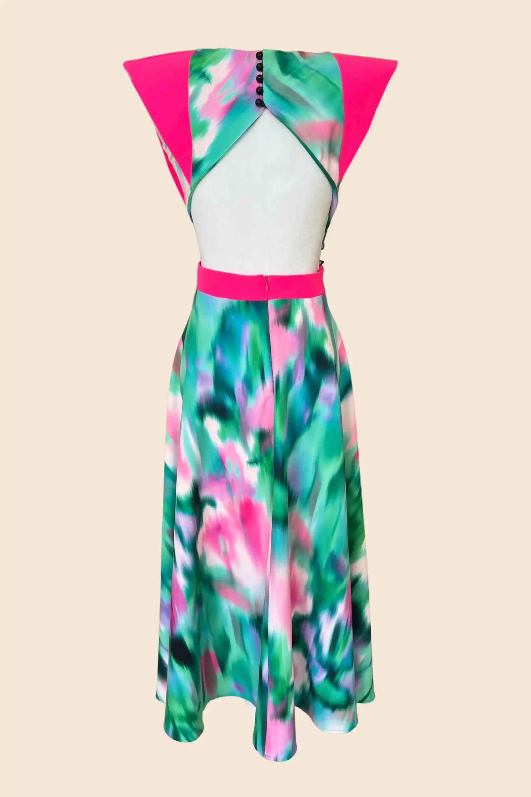 Vestido midi estampado verde y rosa con alerones rosas.