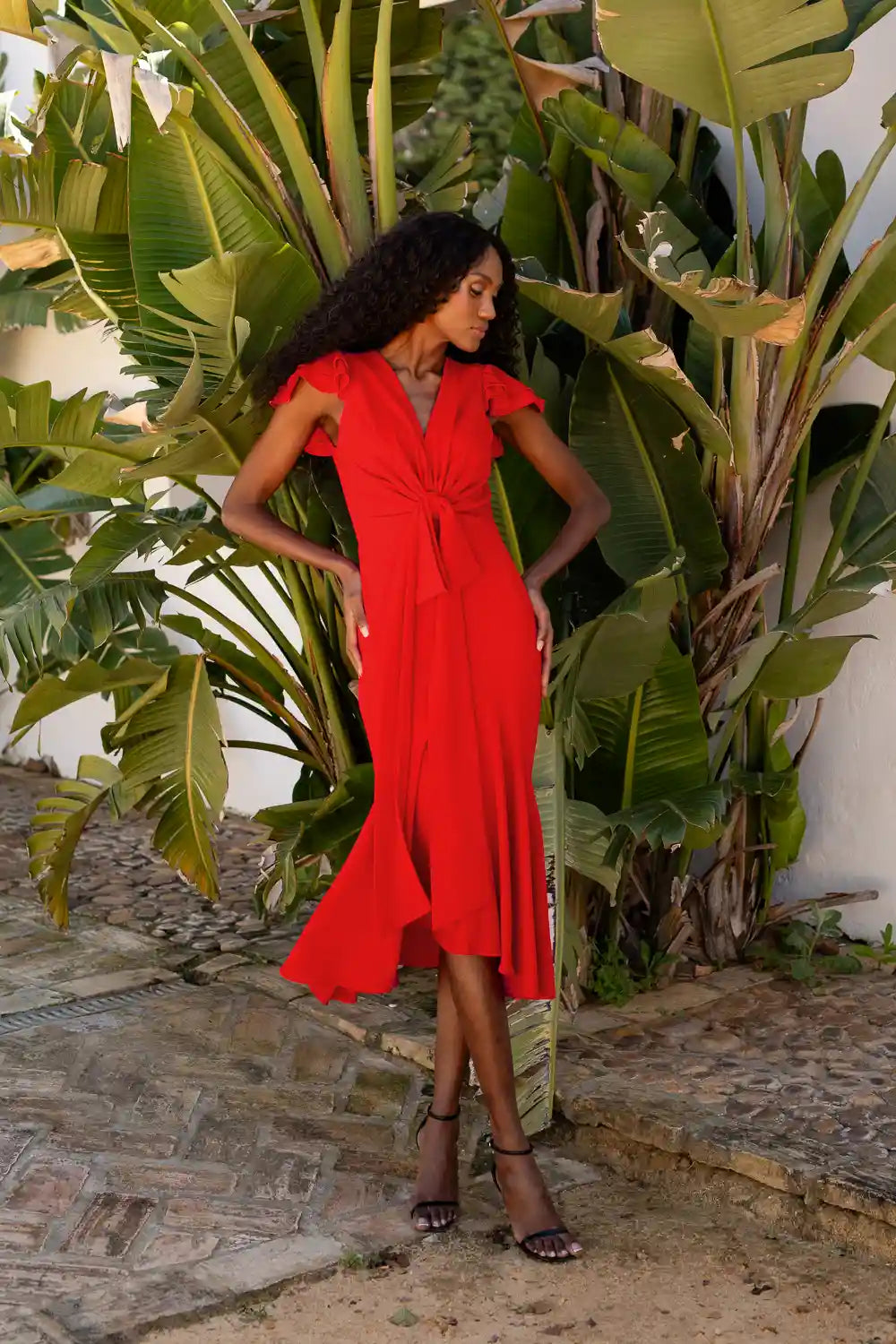 Vestido midi rojo con volantes y lazo en la cintura.