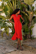 Vestido midi rojo con volantes y lazo en la cintura.