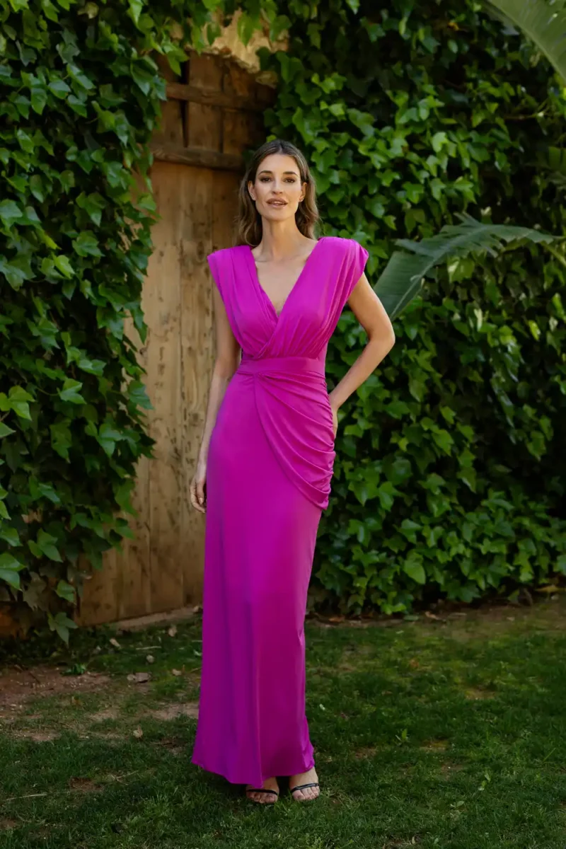Vestido largo de punto con frunce romano. Color fucsia, escote en pico y espalda cerrada.