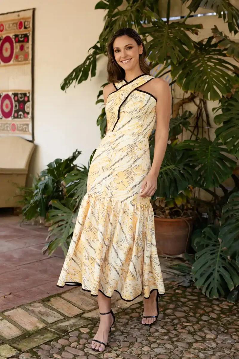Vestido midi estampado amarillo con cuello cruzado.